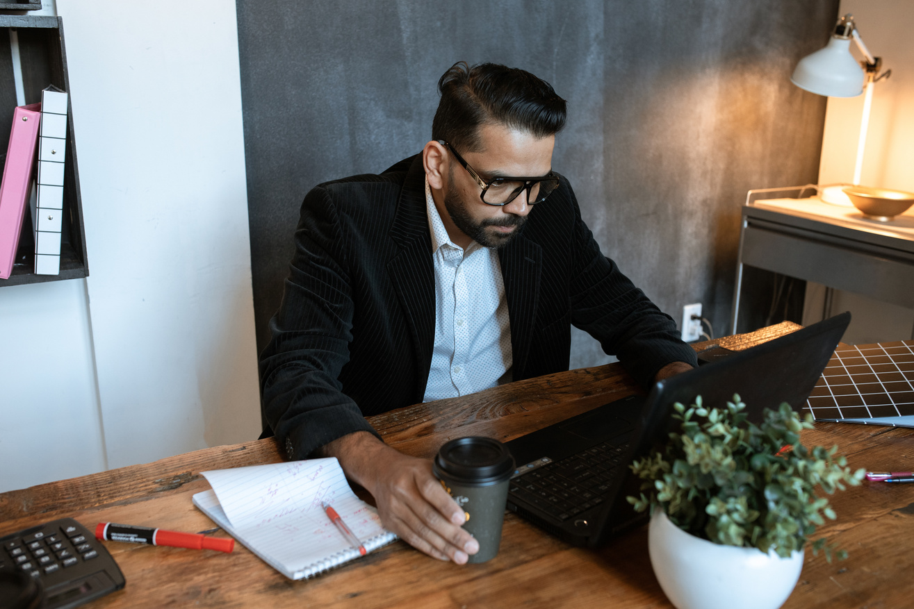 Man in Black Suit Jacket Sitting at the Table